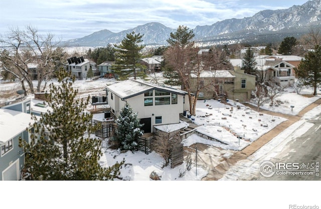 snowy aerial view with a residential view and a mountain view