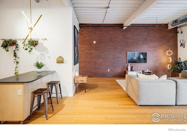 living area with light wood-type flooring and brick wall