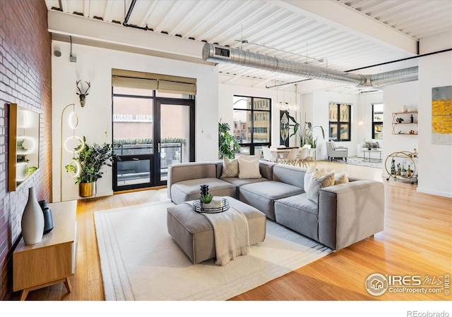 living room featuring light wood-style flooring and brick wall