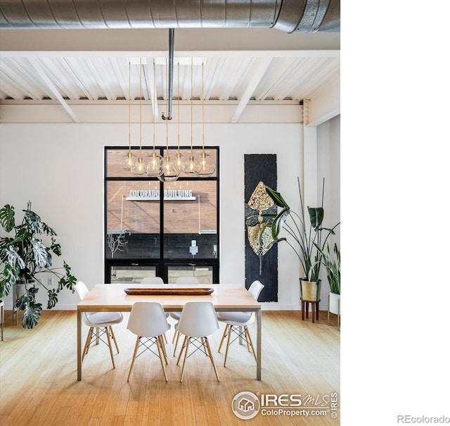 dining space featuring beamed ceiling and wood finished floors