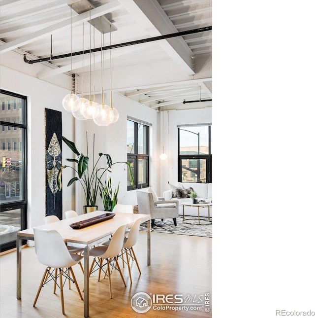 dining room with wood finished floors and beam ceiling