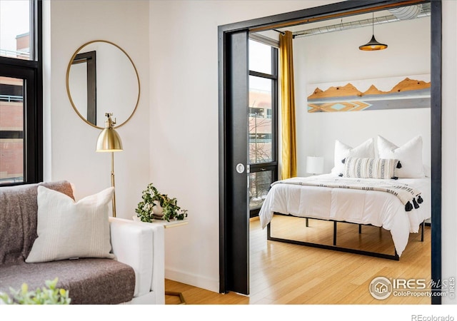 bedroom with baseboards and wood finished floors