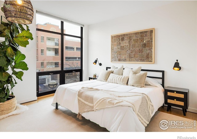 bedroom featuring light wood-style floors and expansive windows