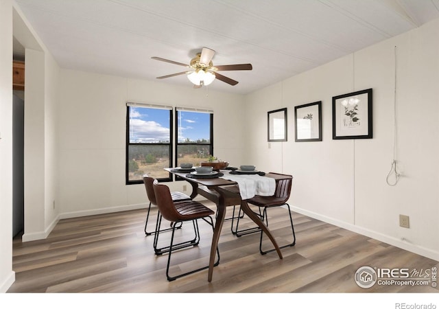 dining area featuring ceiling fan, baseboards, and wood finished floors