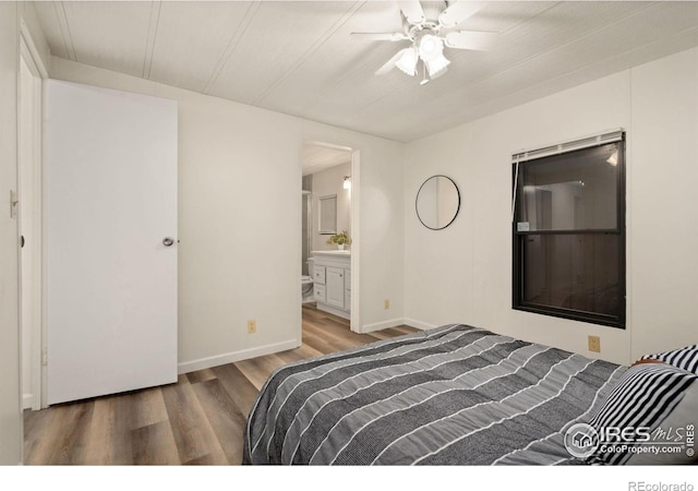 bedroom featuring ensuite bath, baseboards, and wood finished floors