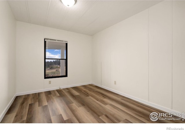 empty room with wood finished floors and baseboards