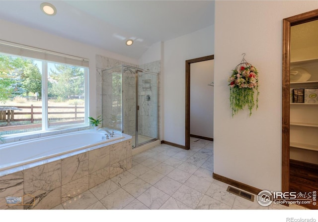 bathroom with a garden tub, visible vents, baseboards, vaulted ceiling, and a shower stall