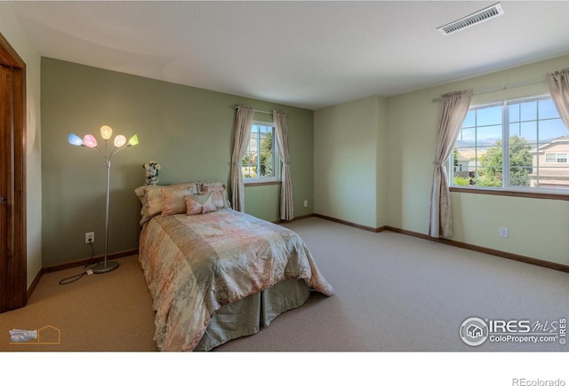 bedroom featuring light colored carpet, visible vents, and baseboards