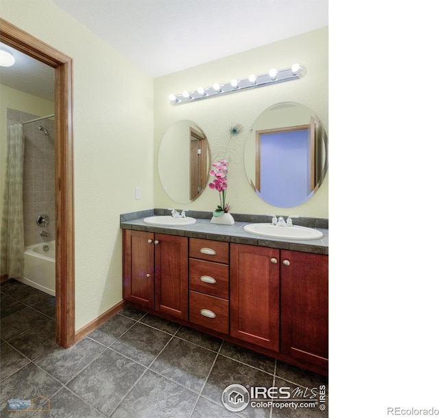 full bath with shower / tub combo, tile patterned flooring, a sink, and double vanity