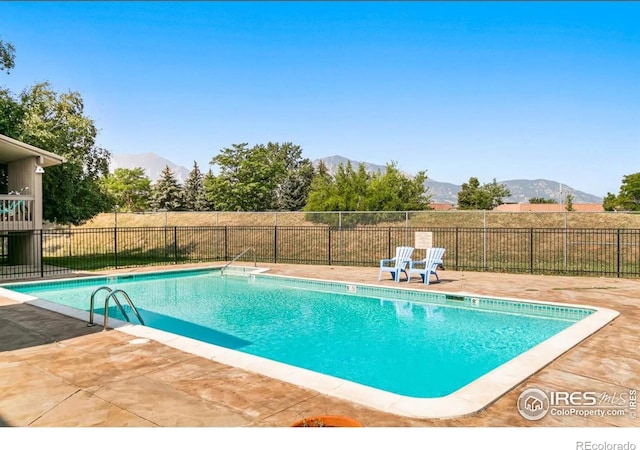 view of swimming pool featuring a fenced in pool, a mountain view, a patio, and fence