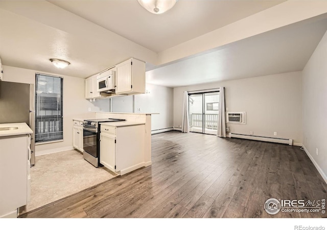 kitchen with stainless steel appliances, white cabinets, light countertops, and a baseboard heating unit