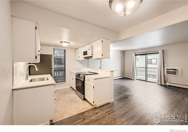 kitchen featuring light countertops, white microwave, white cabinetry, a sink, and stainless steel electric range