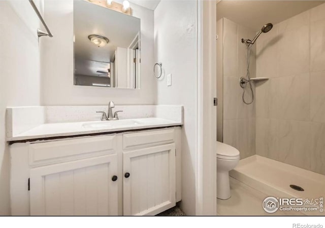 bathroom with vanity, a shower stall, and toilet