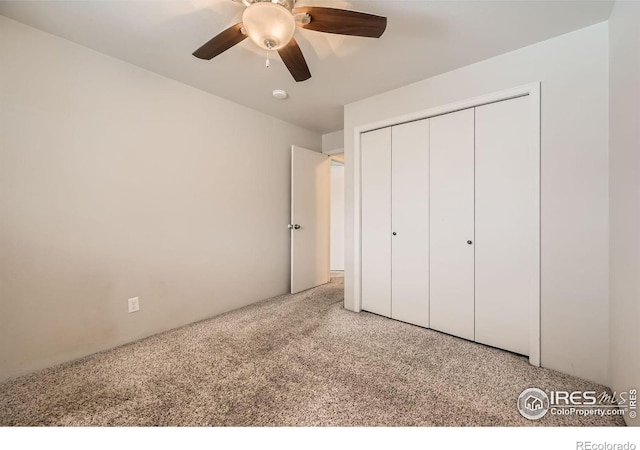 unfurnished bedroom with light carpet, a closet, and a ceiling fan