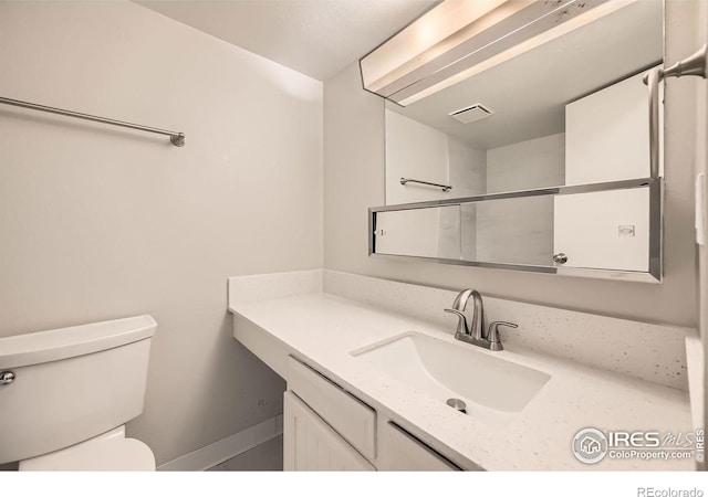 bathroom featuring visible vents, vanity, and toilet