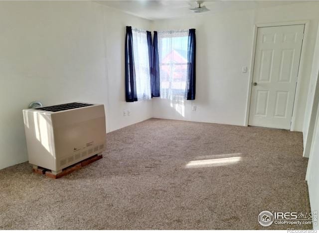 carpeted empty room with heating unit