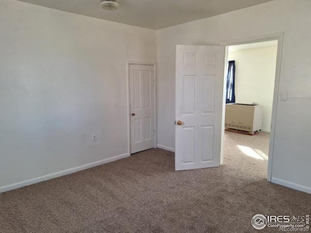 unfurnished bedroom featuring carpet flooring and baseboards