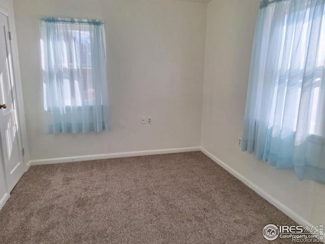 empty room with carpet flooring and baseboards