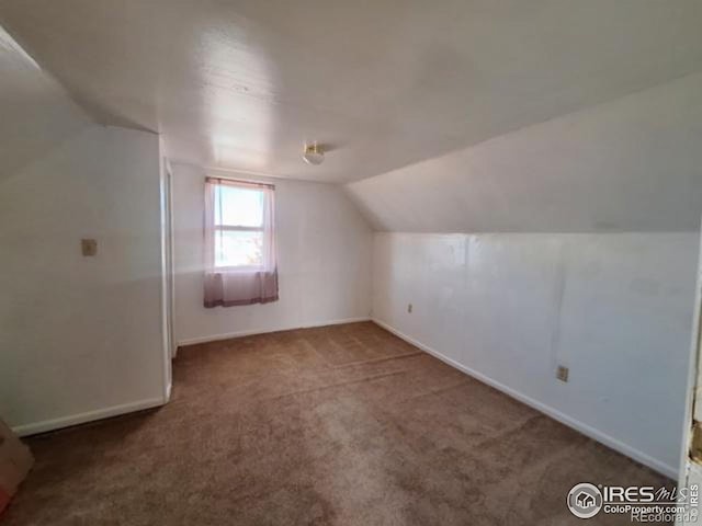 additional living space featuring vaulted ceiling, carpet, and baseboards