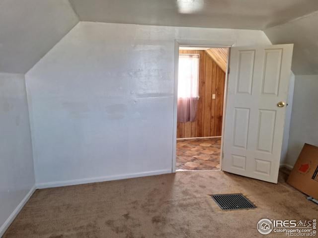 additional living space featuring carpet floors, baseboards, visible vents, and vaulted ceiling