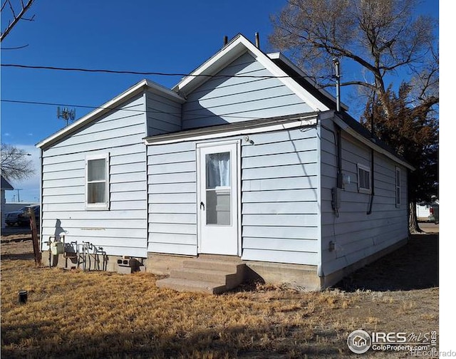 rear view of house with entry steps and crawl space