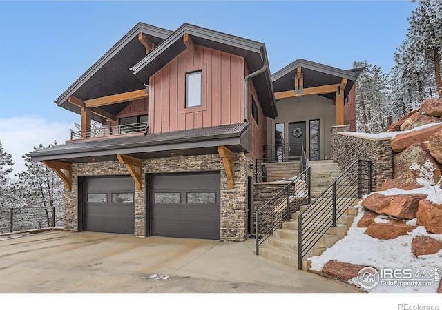 view of front of home featuring a garage, stone siding, board and batten siding, and concrete driveway