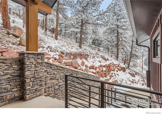 view of snow covered back of property