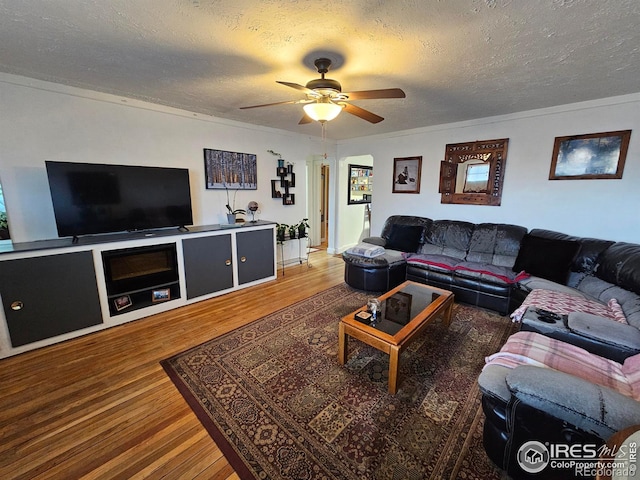 living room with a textured ceiling, wood finished floors, and a ceiling fan