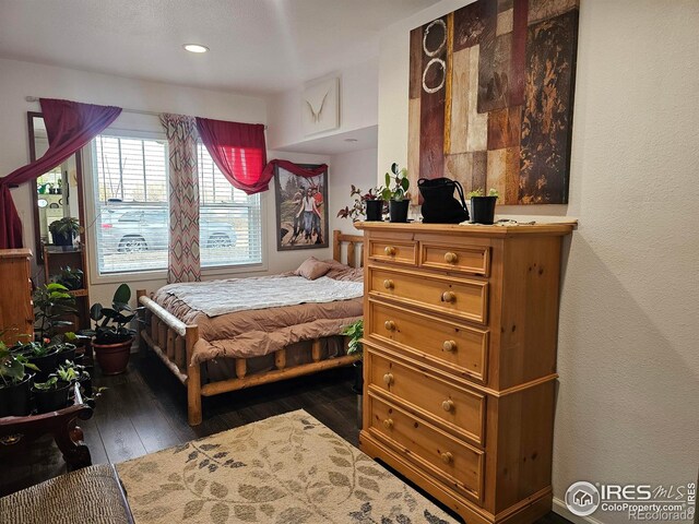 bedroom with dark wood-type flooring