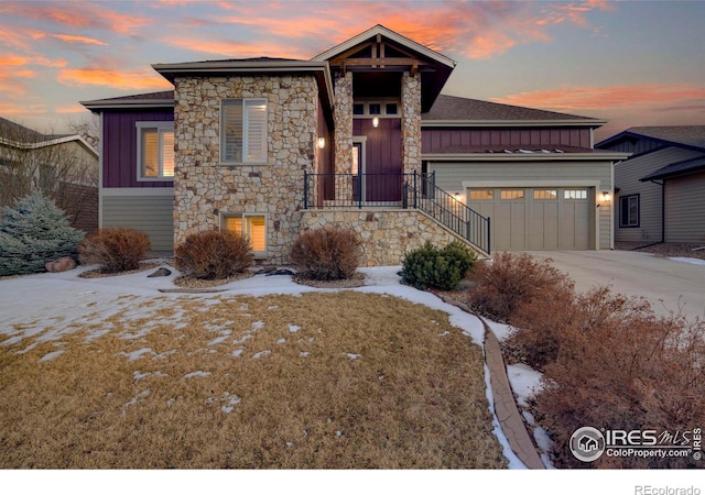 view of front of house featuring an attached garage, concrete driveway, board and batten siding, and stone siding