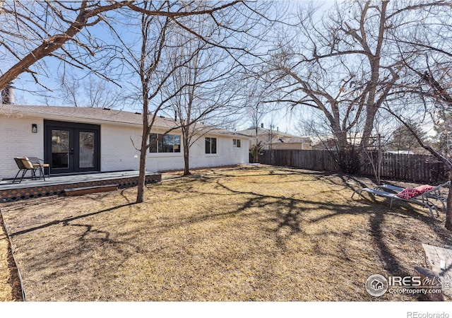 view of yard featuring a fenced backyard and french doors