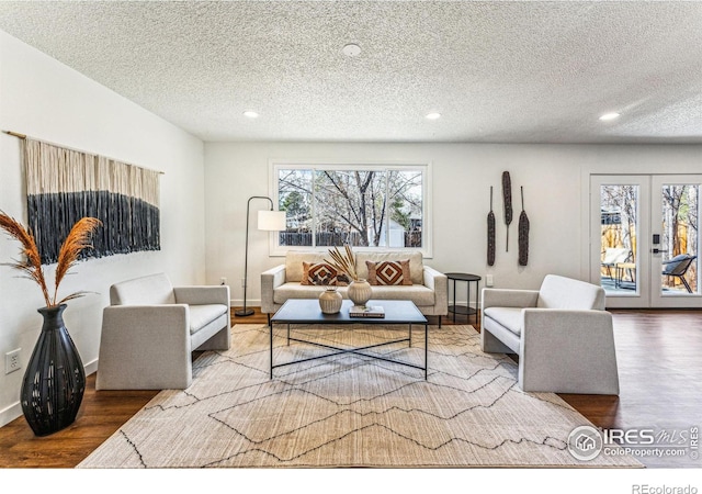 living area with recessed lighting, baseboards, wood finished floors, and french doors