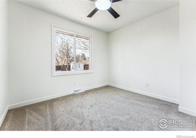 carpeted spare room featuring a ceiling fan, baseboards, visible vents, and a textured ceiling