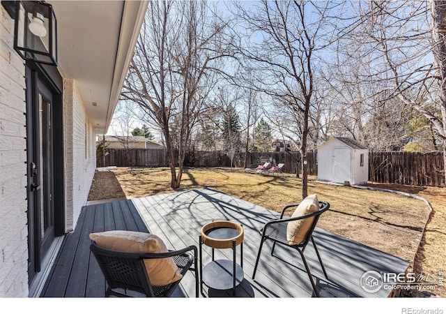 wooden deck with an outbuilding, a fenced backyard, and a storage shed