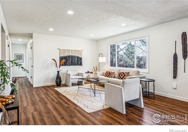 living room featuring a textured ceiling, dark wood-type flooring, and recessed lighting