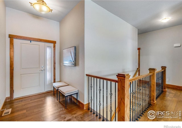 foyer featuring baseboards, visible vents, and hardwood / wood-style floors