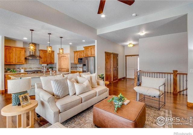 living room with a ceiling fan, wood finished floors, and recessed lighting