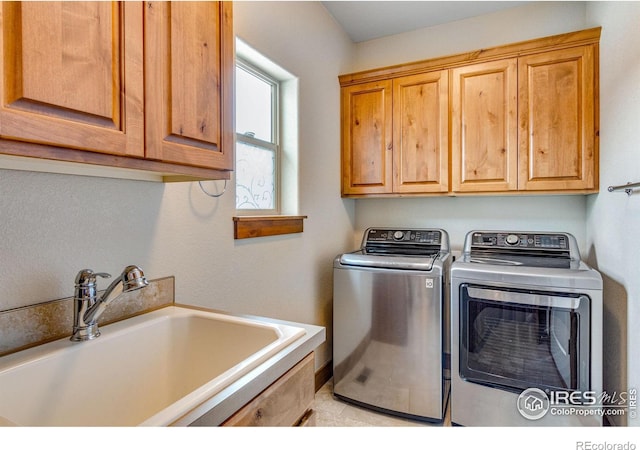 laundry area with washer and clothes dryer, a sink, and cabinet space