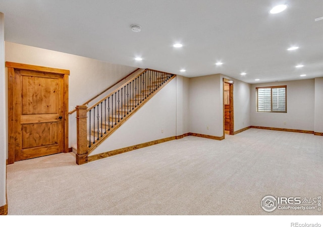 basement with baseboards, stairway, recessed lighting, and light colored carpet