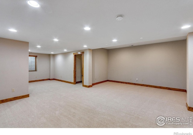 below grade area featuring recessed lighting, baseboards, and light colored carpet