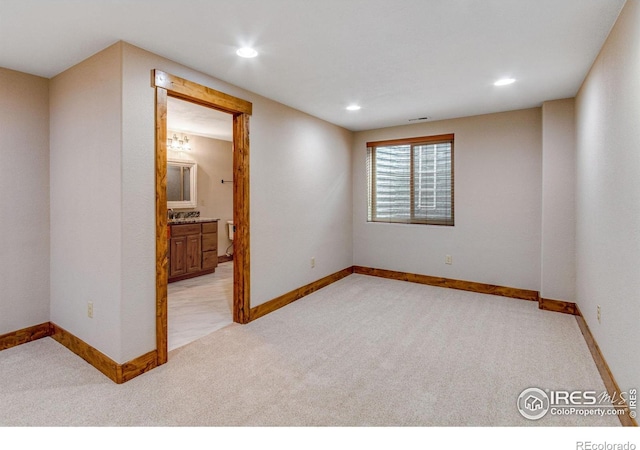 unfurnished room with recessed lighting, light colored carpet, and baseboards