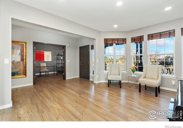 living area featuring light wood-type flooring, baseboards, and recessed lighting