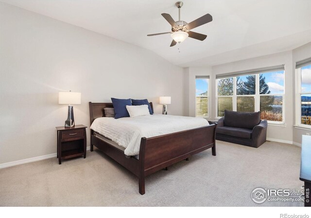 bedroom with light carpet, lofted ceiling, and baseboards