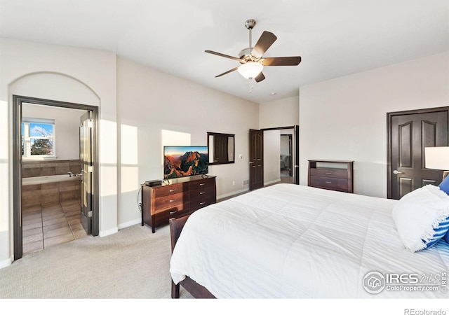 bedroom featuring ceiling fan, baseboards, connected bathroom, and light colored carpet