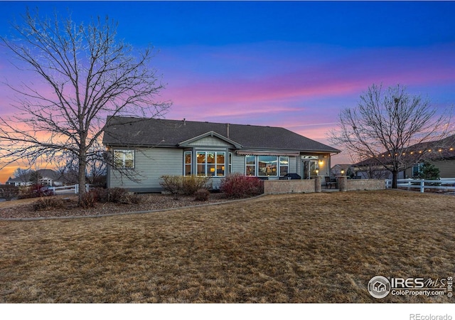 view of front of home featuring fence and a yard