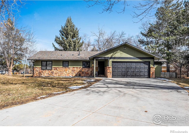 ranch-style house with stone siding, concrete driveway, fence, and an attached garage