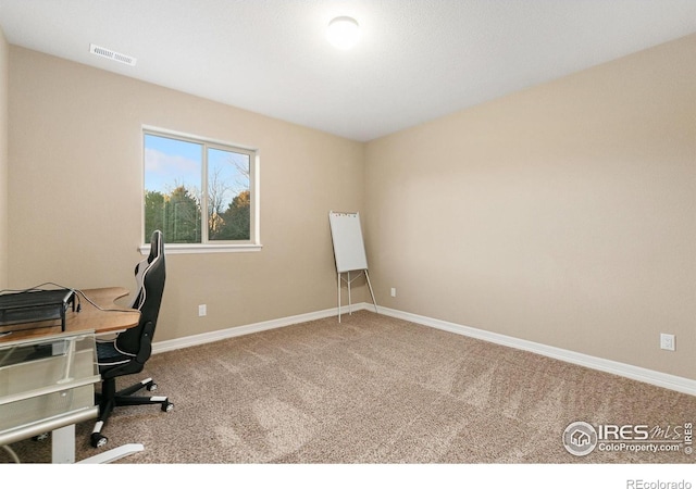 carpeted office with visible vents and baseboards