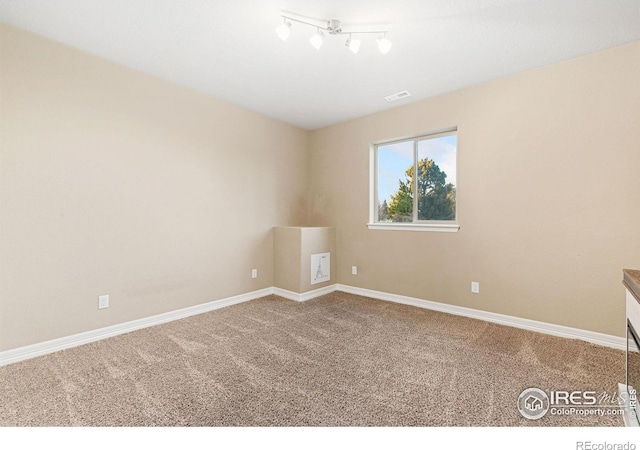 carpeted empty room with visible vents and baseboards