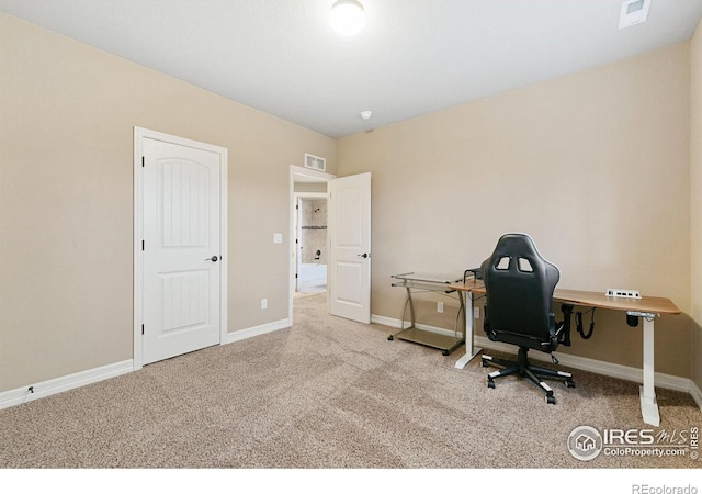 office featuring baseboards, visible vents, and light colored carpet