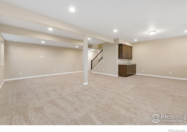 finished basement featuring recessed lighting, light colored carpet, baseboards, and stairs